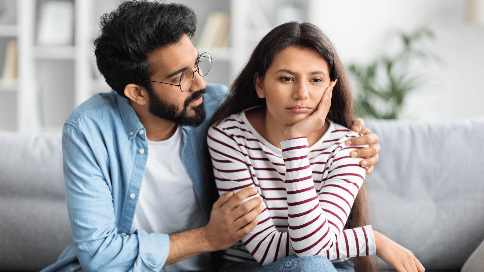 man hugging woman while woman looks done