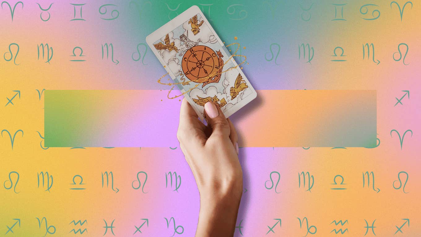 hand holding tarot card for weekly tarot horoscopes zodiac signs