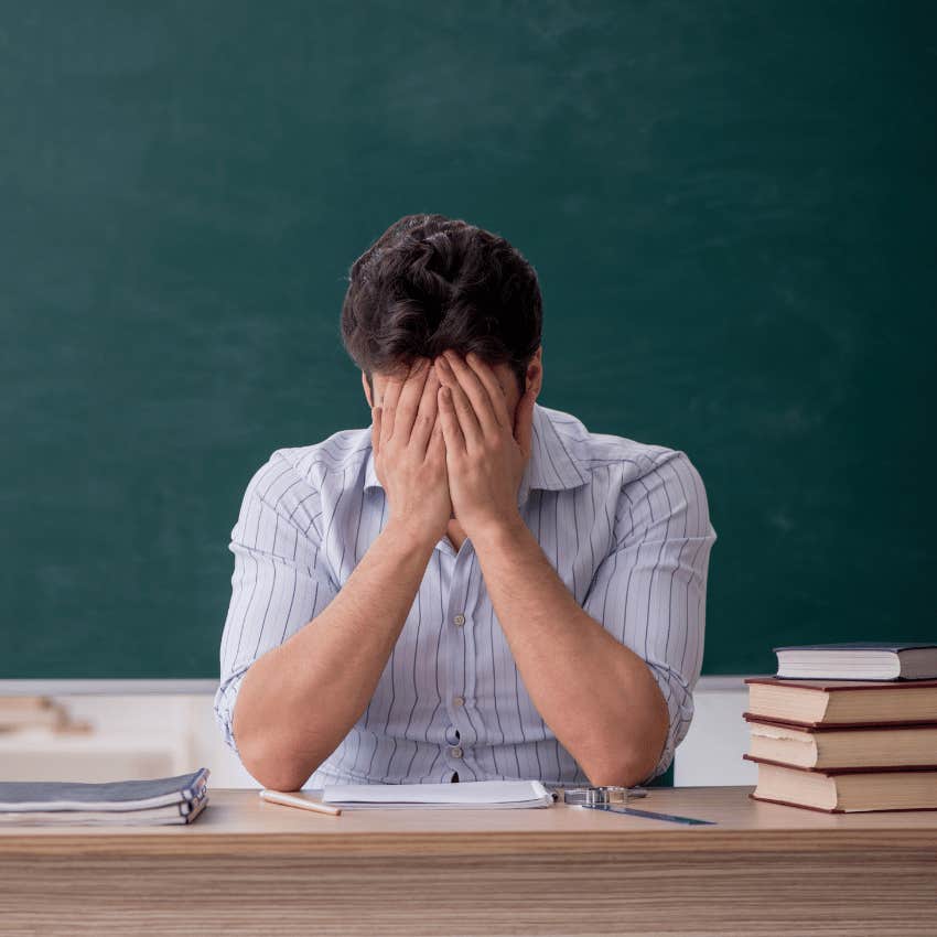 teacher with his head in his hands