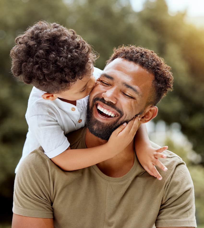 Children sits on smiling man's shoulders