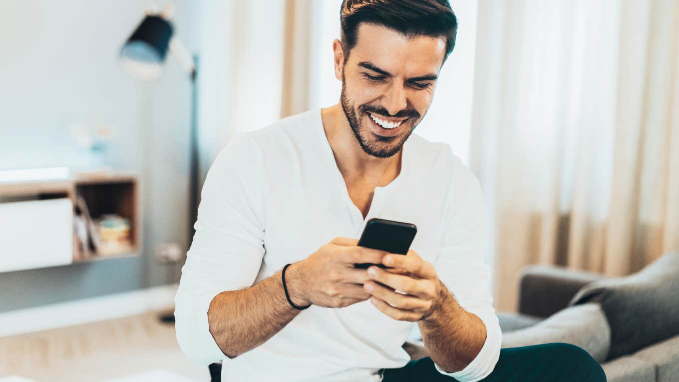 Man texting a woman, smiling.