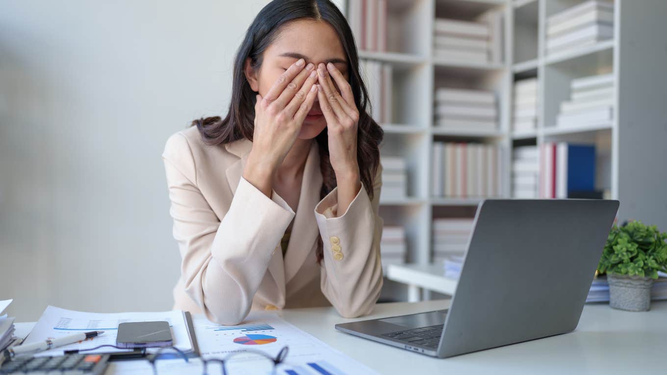 stressed business woman with her hands over her face