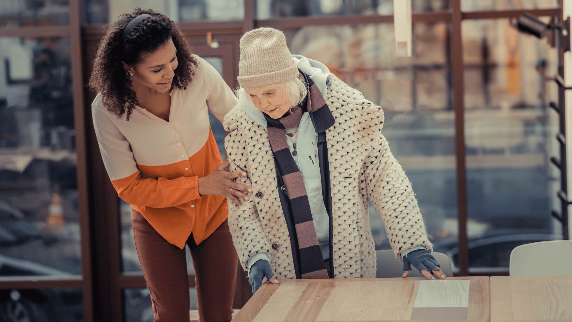 woman helping older woman up 