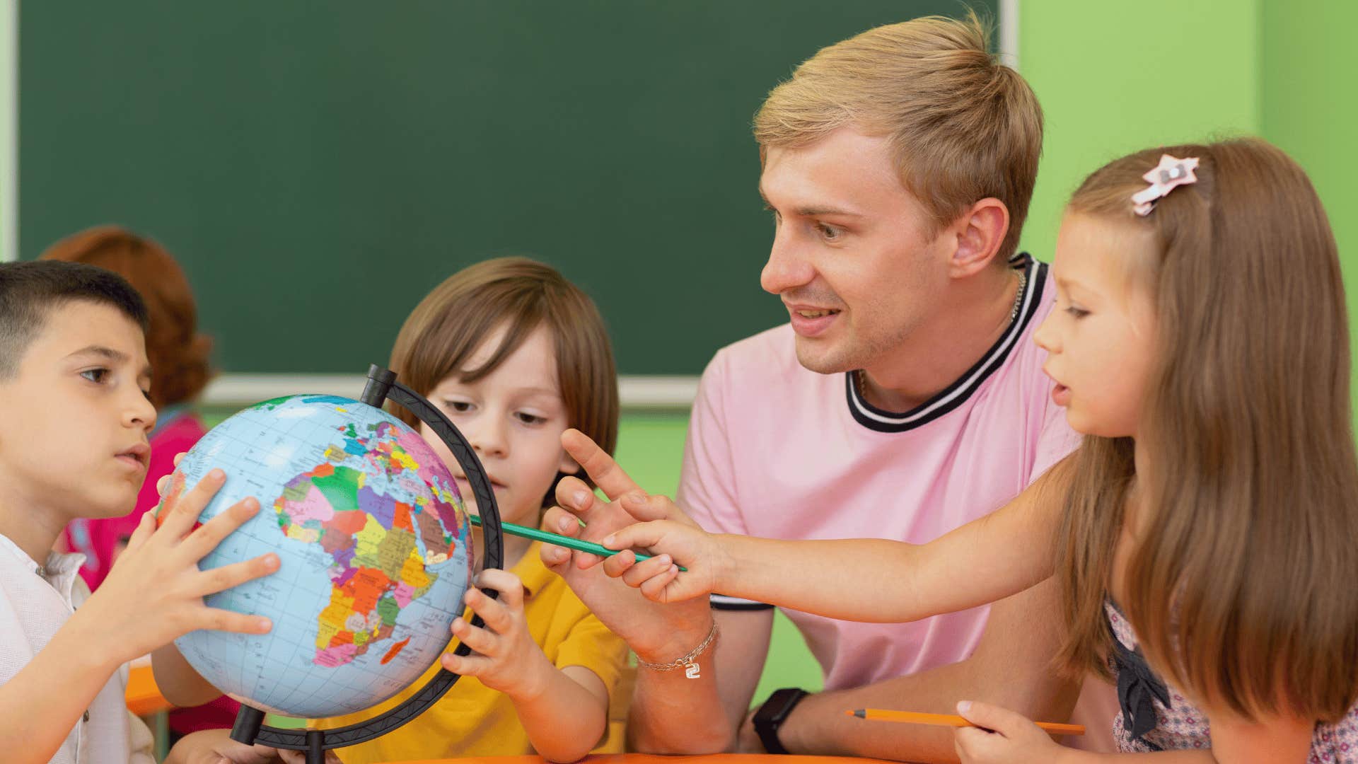 teacher showing students a globe