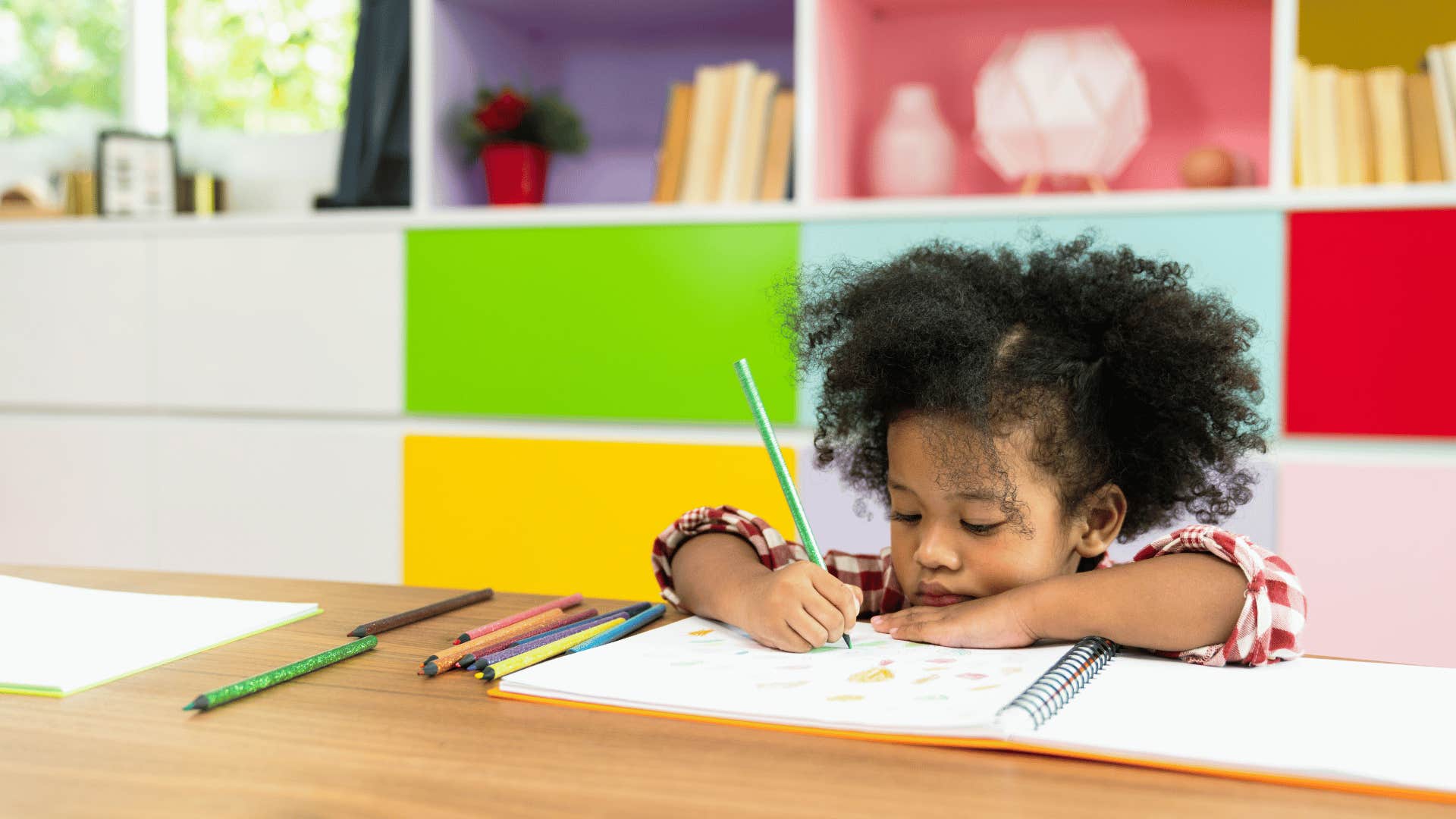 little girl drawing at school that doesn't have manual pencil sharpeners