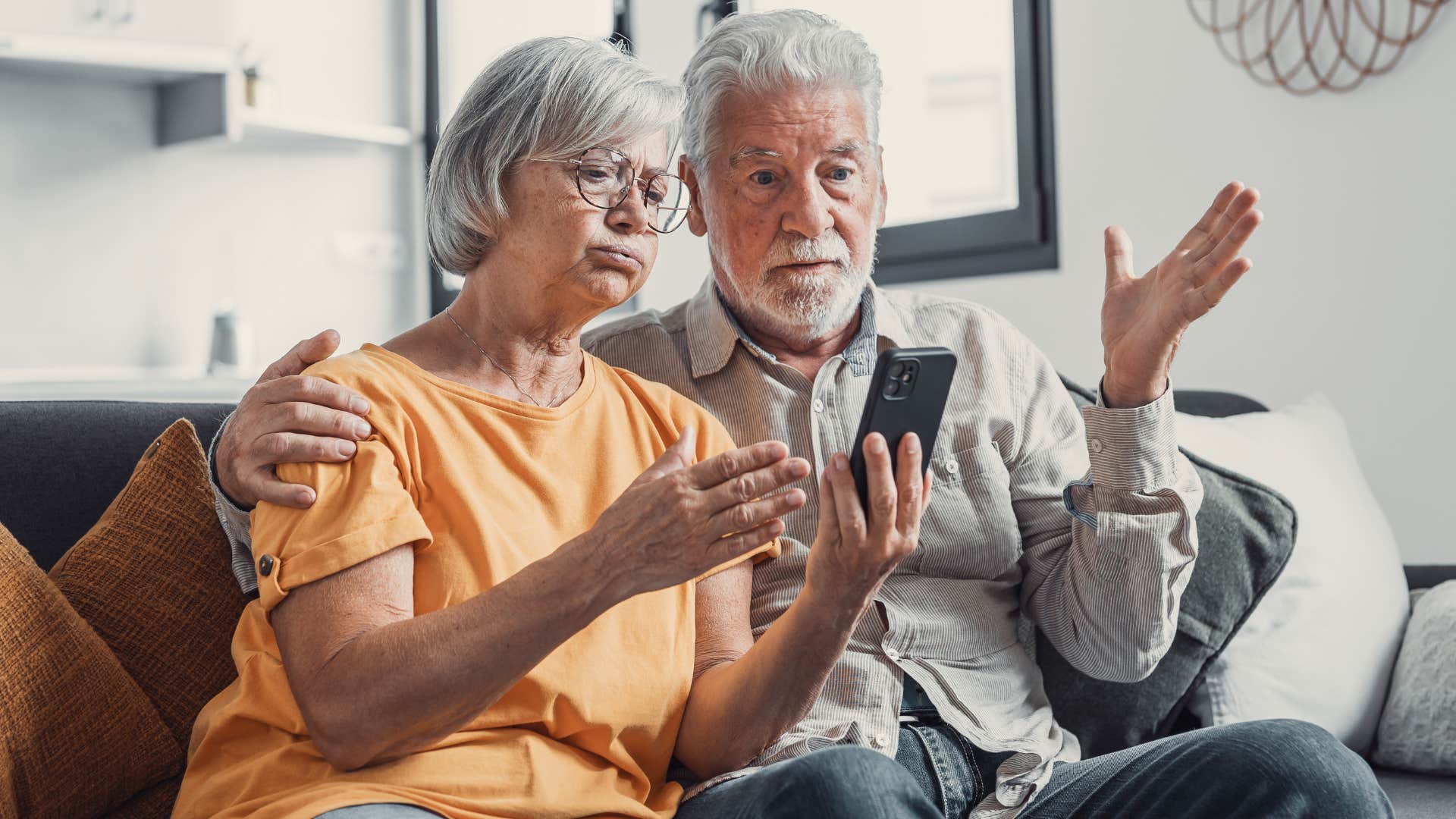 Older couple looking shocked at their cell phone. 