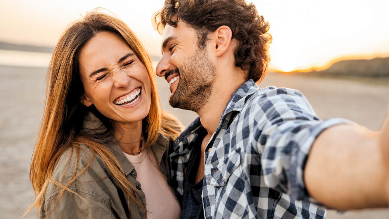 Woman in love with man, smiling taking selfie.