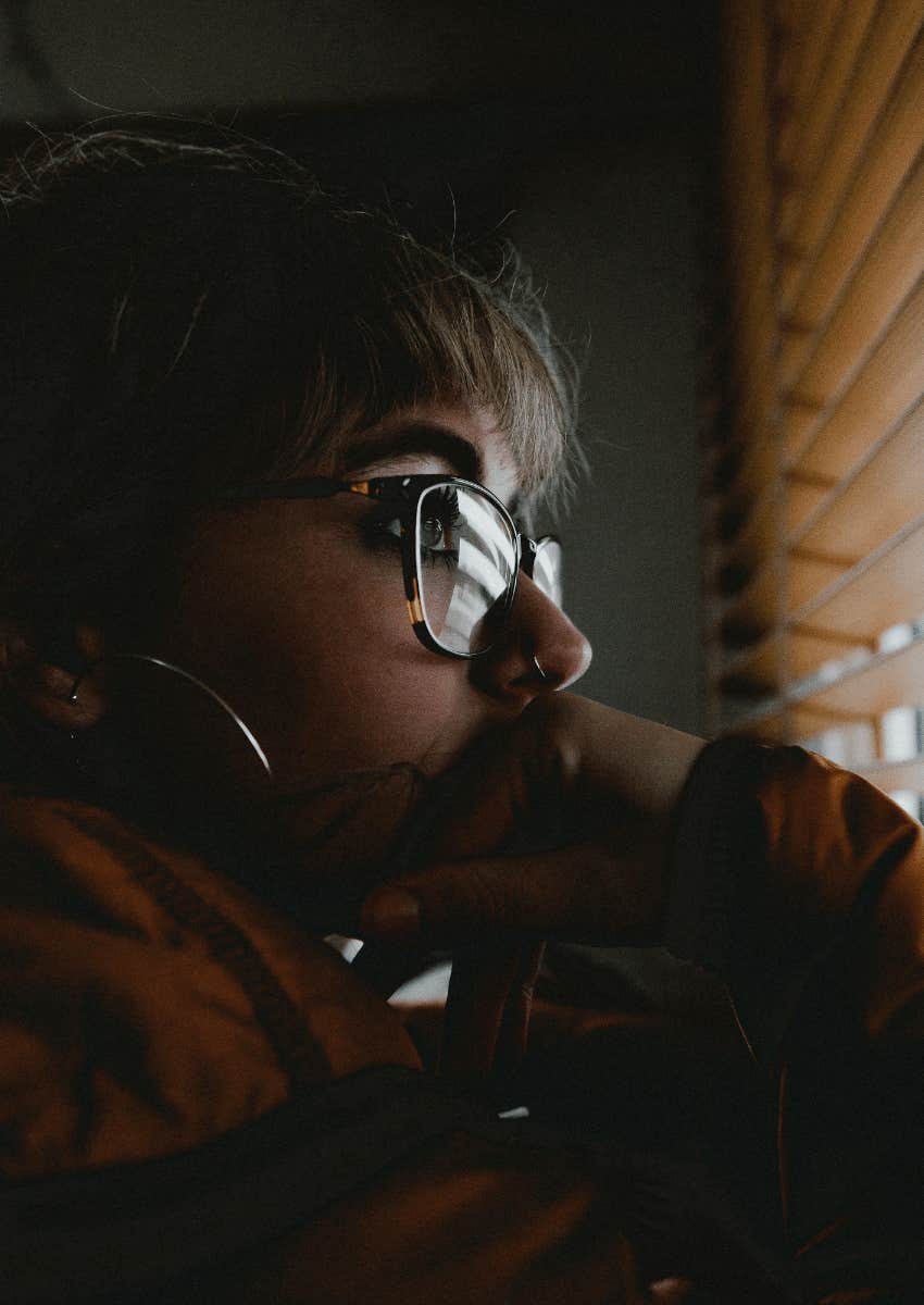 thoughtful woman looking out of window