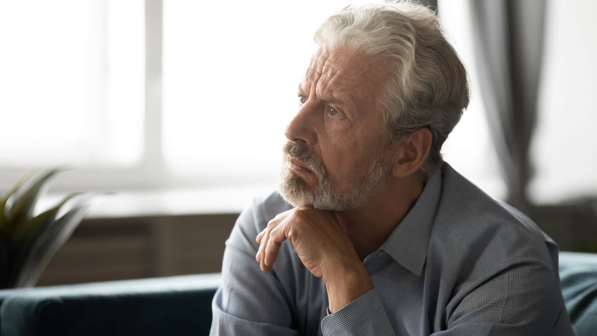 Older man looking upset staring away from the camera.