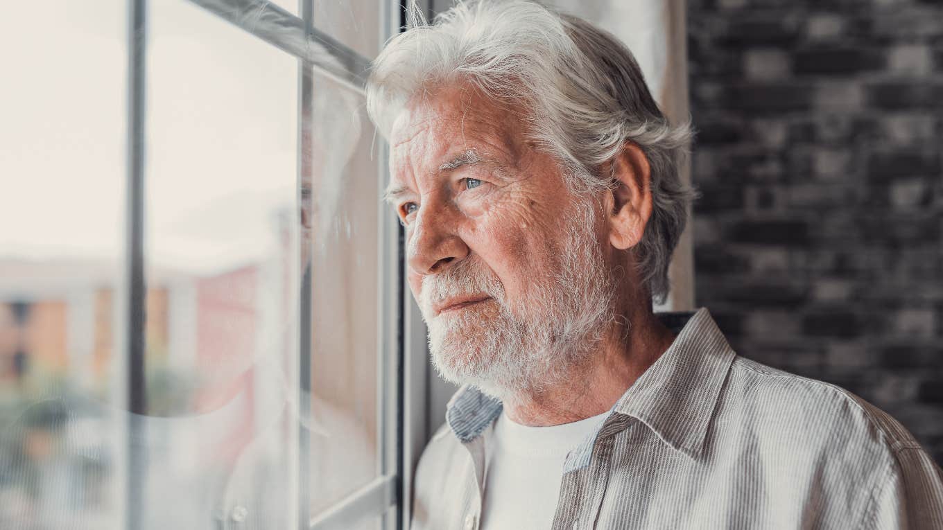 Older man looking sadly out of the window