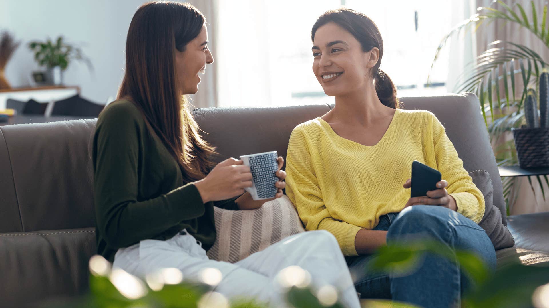 two women chatting on couch