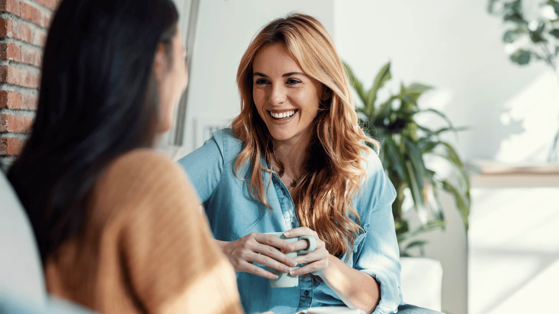 two women chatting on couch