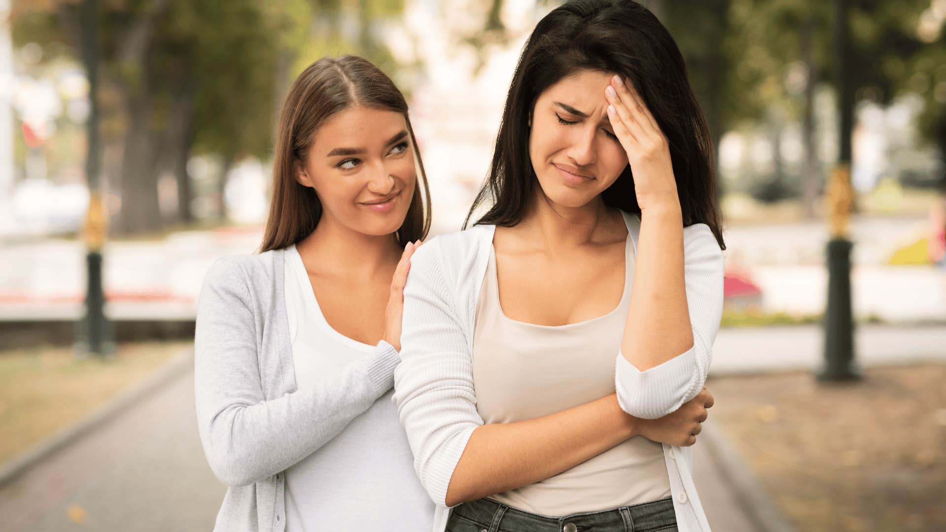 woman fake comforting crying friend