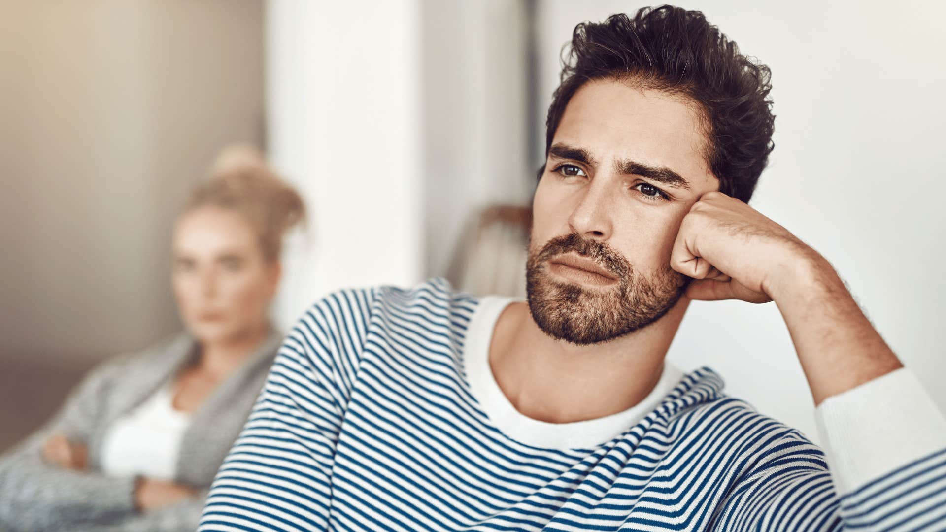 man thinking and ignoring woman on couch