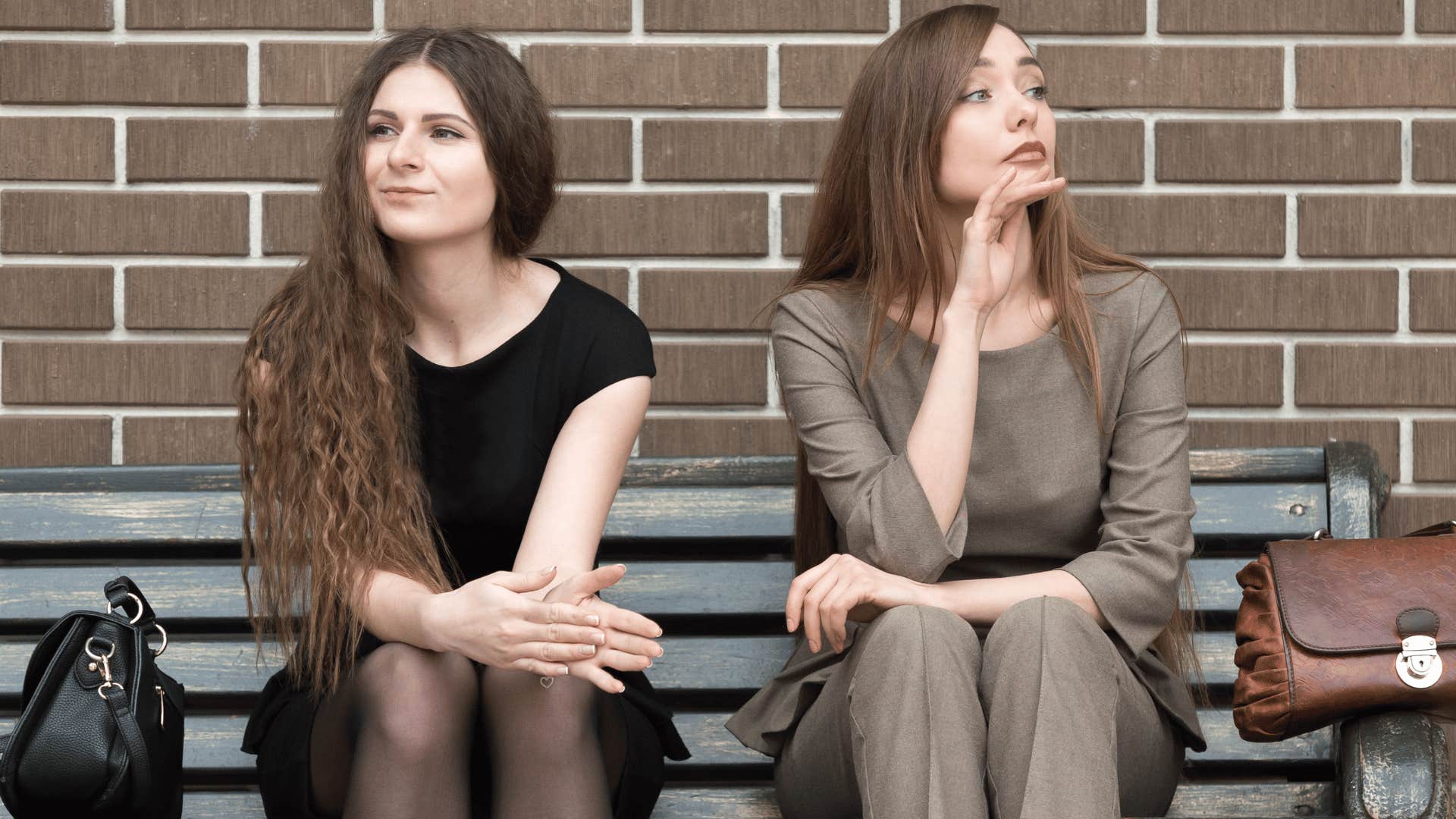 two women ignoring each other on bench