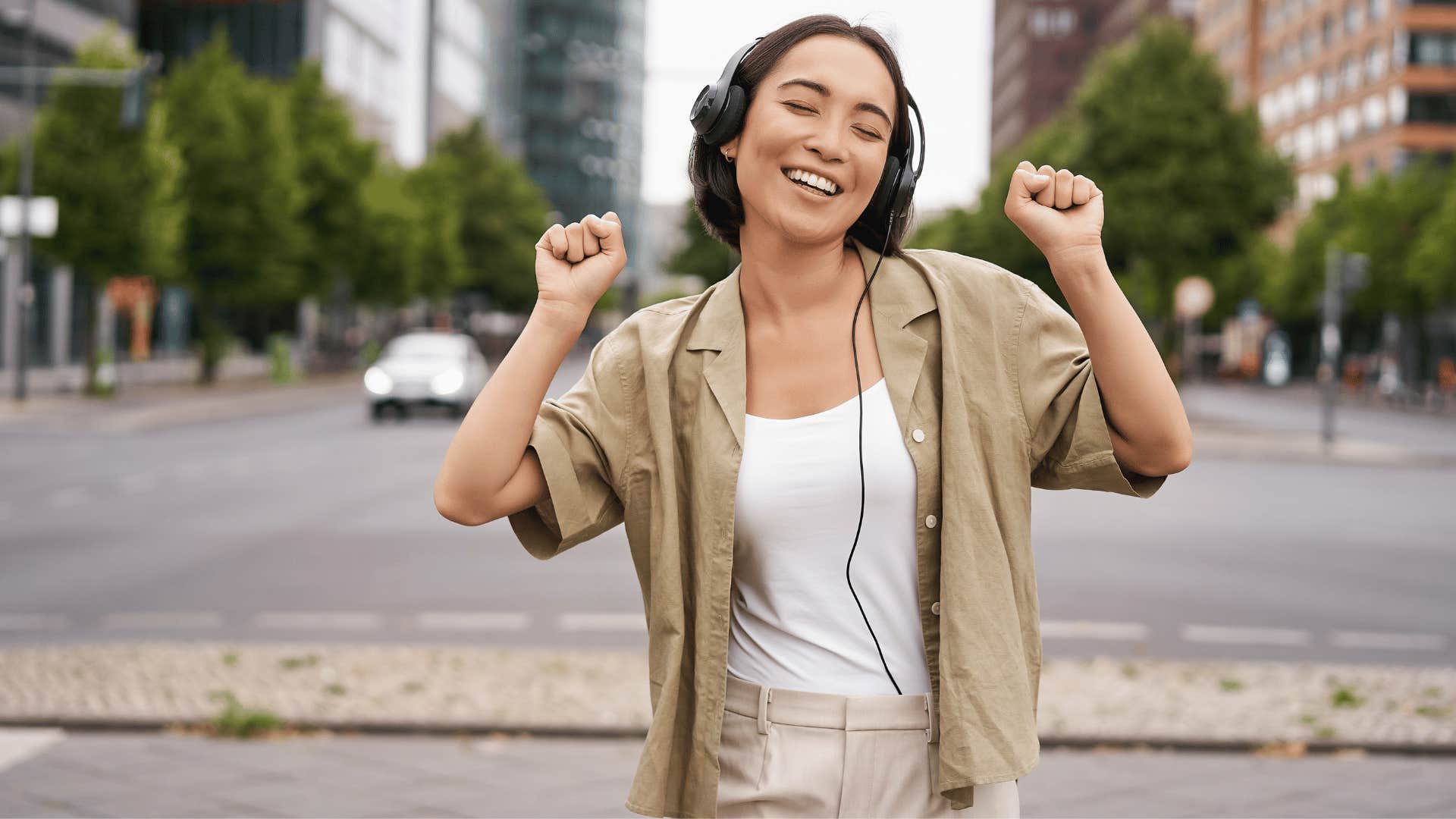 woman jamming out to music while outside 