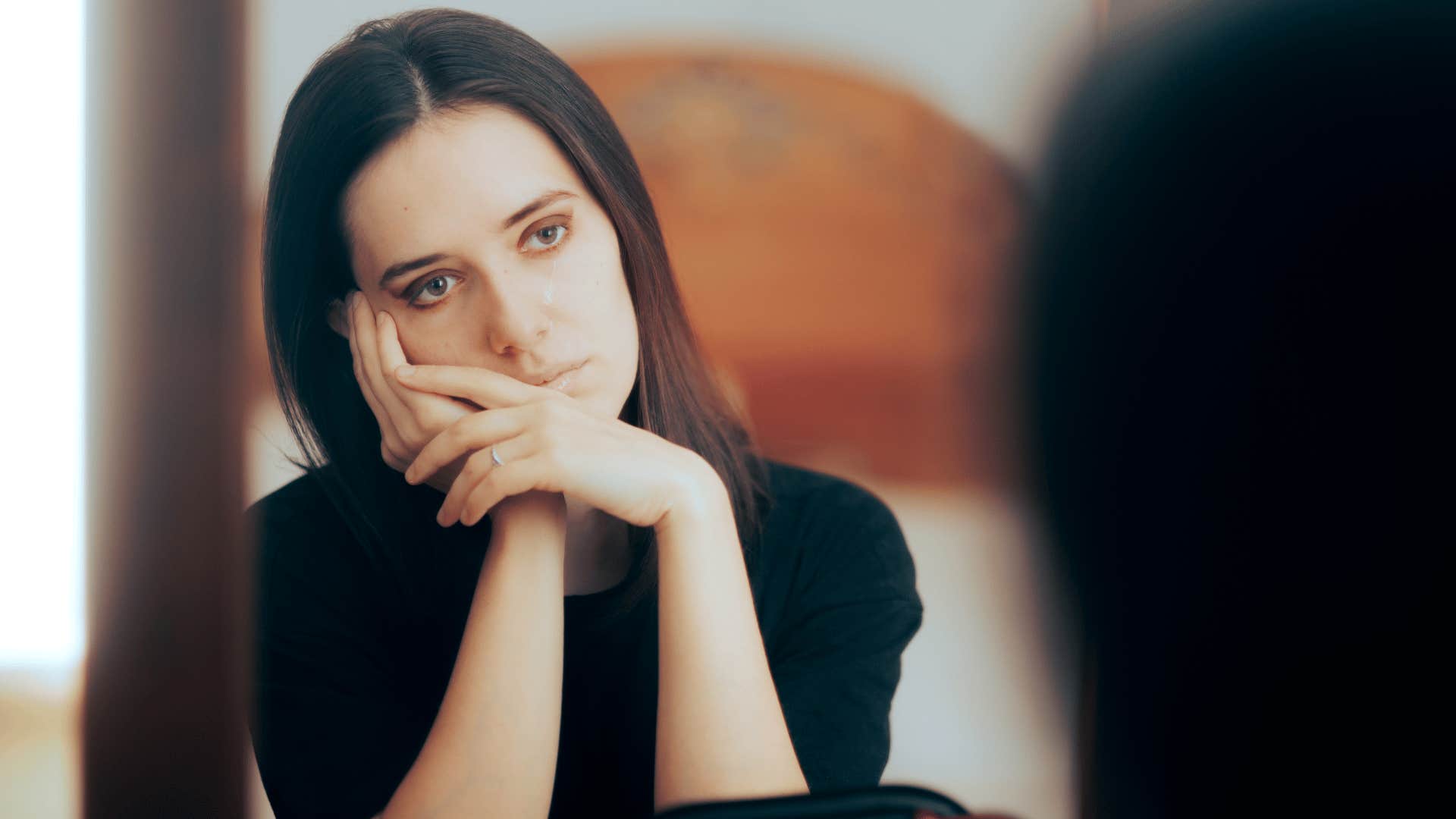 woman staring at herself in mirror