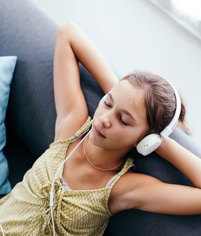 Tween girl sitting on couch with headphones