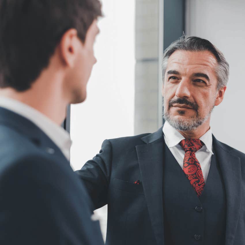 two men in dark suits talking