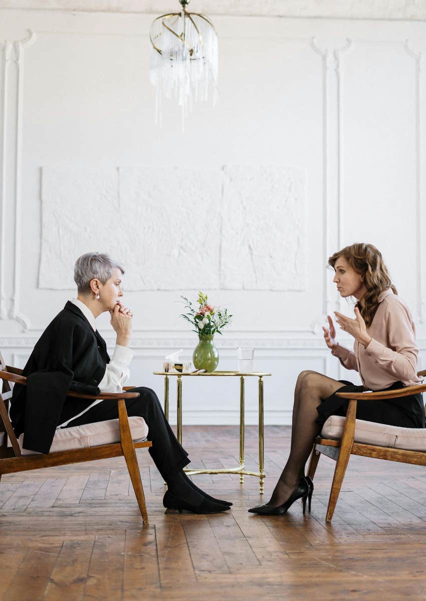 two women sitting across from each other having a conversation