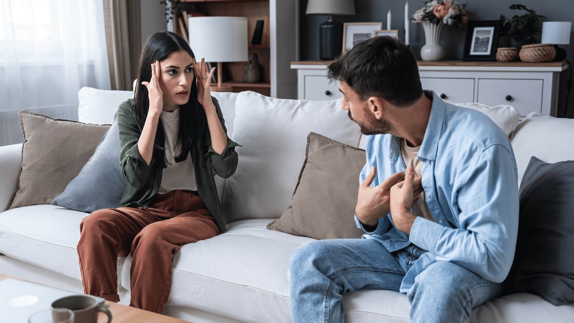 man and woman arguing on couch