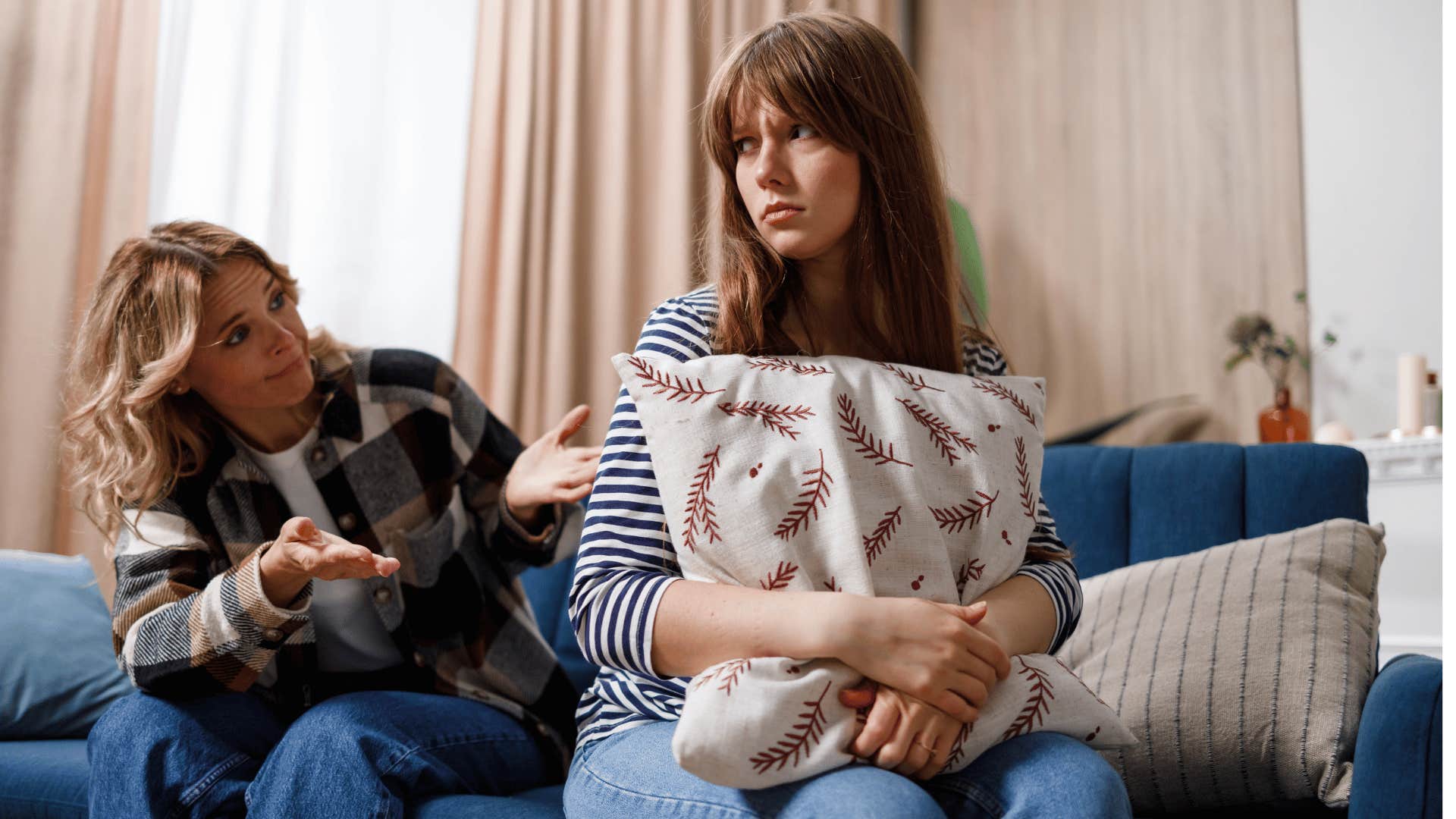 woman holding pillow turned away from mother