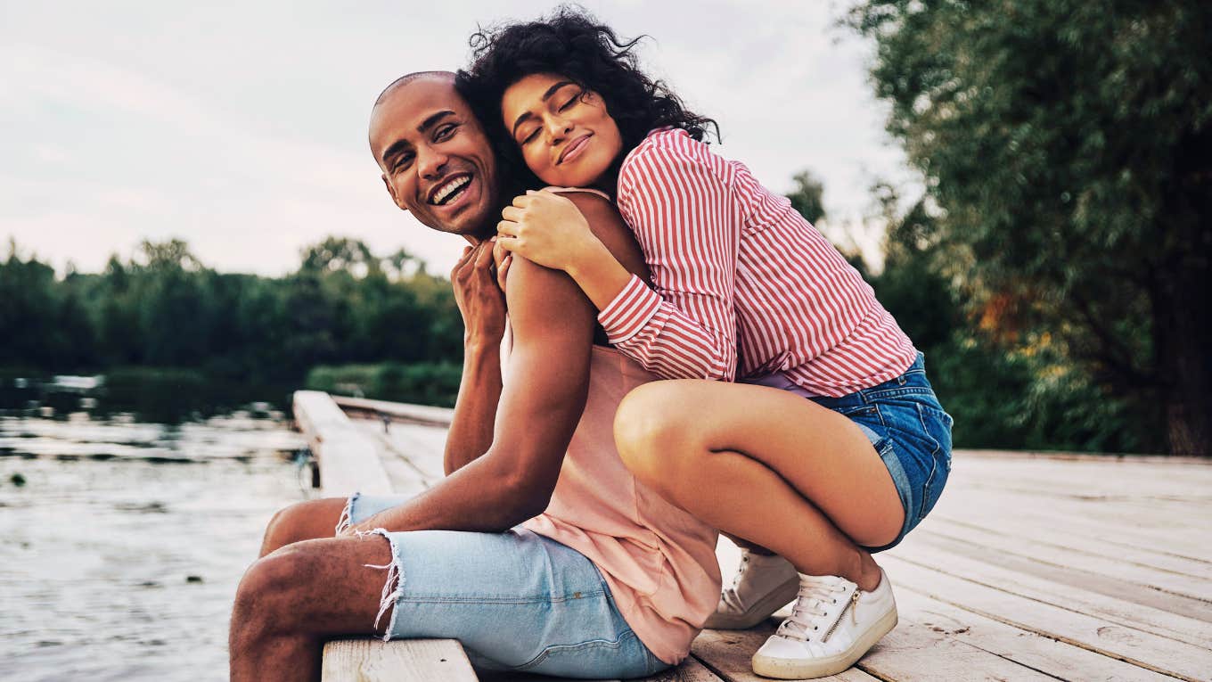 Compatible couple snuggling on a dock