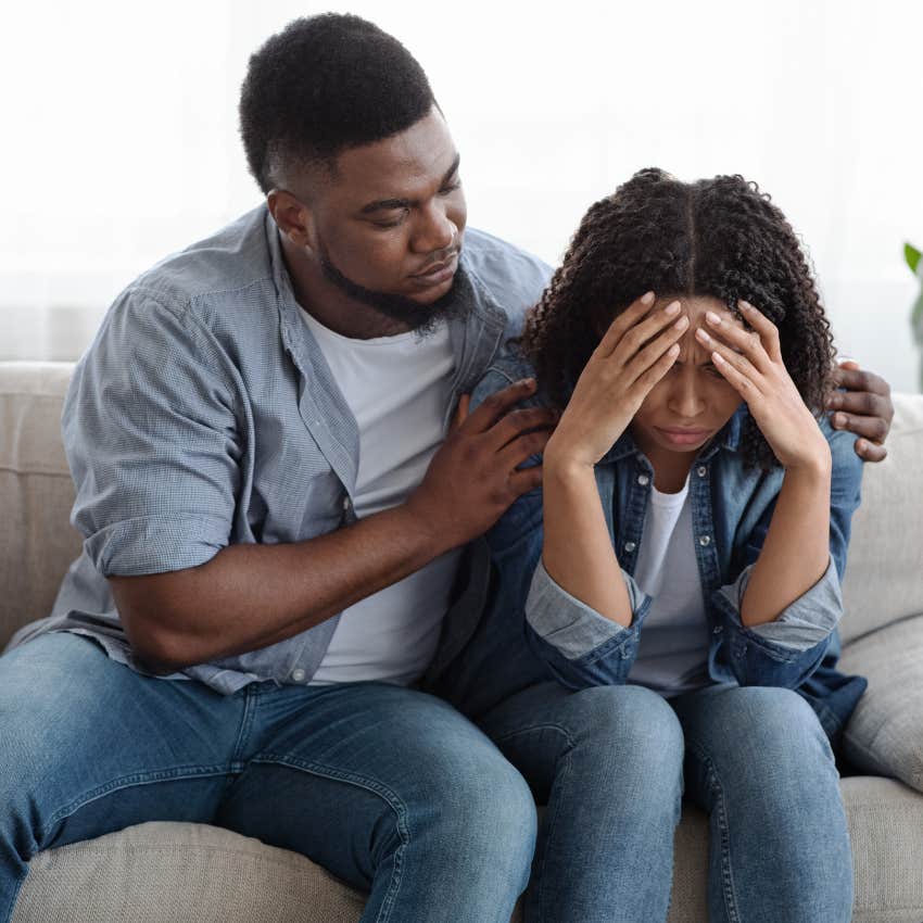 Girlfriend looking upset while her boyfriend hugs her. 