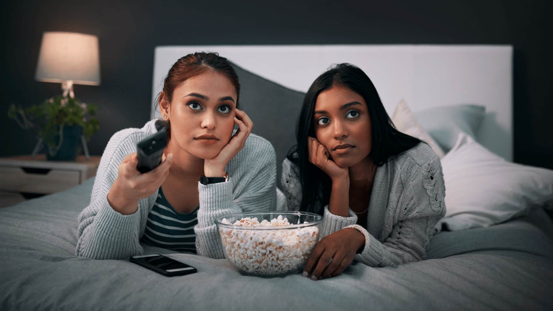 Couple lays on bed to watch TV