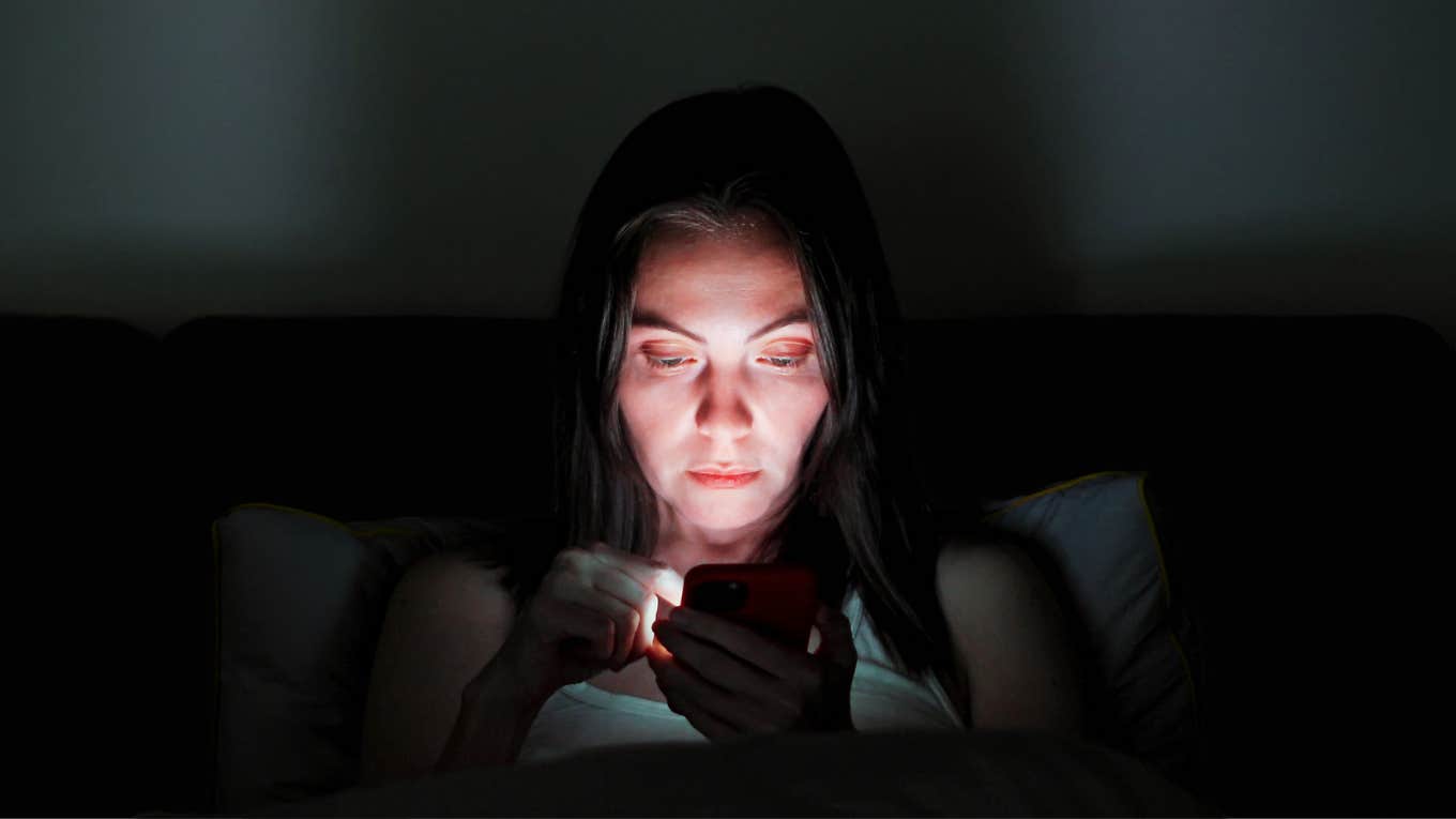 Woman looking at her exes social media at night before bed. 