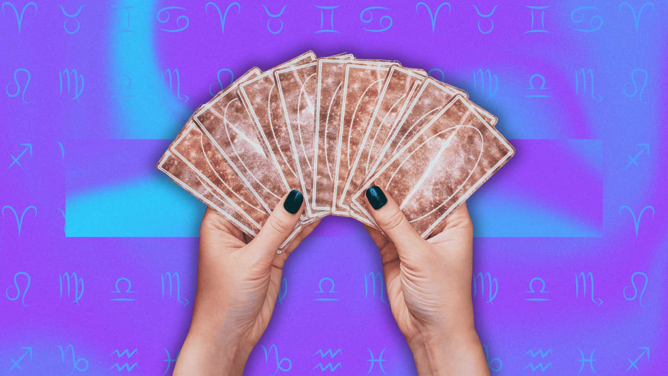 hands holding tarot cards for weekly horoscope reading november 4 - 10, 2024