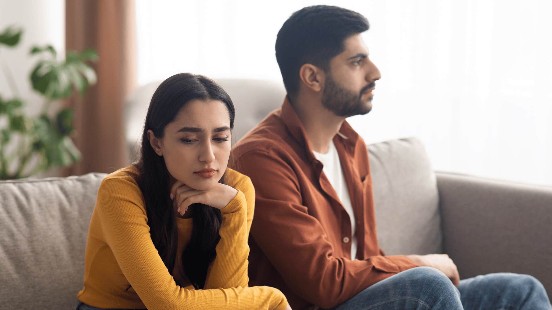 Unhappy couple sit uncomfortably