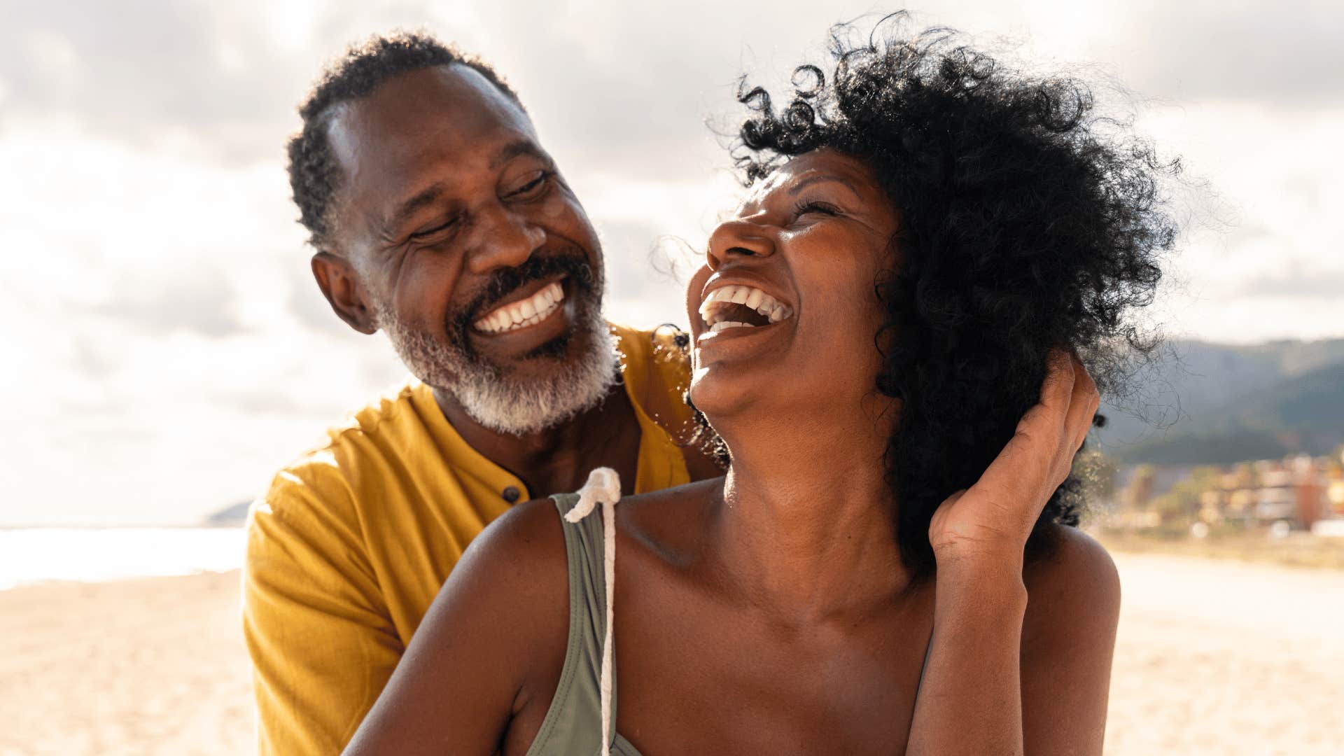 Happy couple laughing on the beach