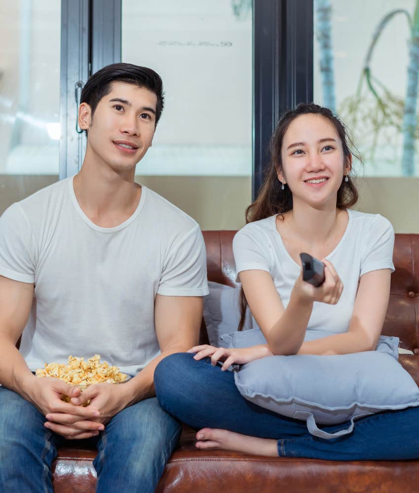 husband and wife watching movie together on a couch