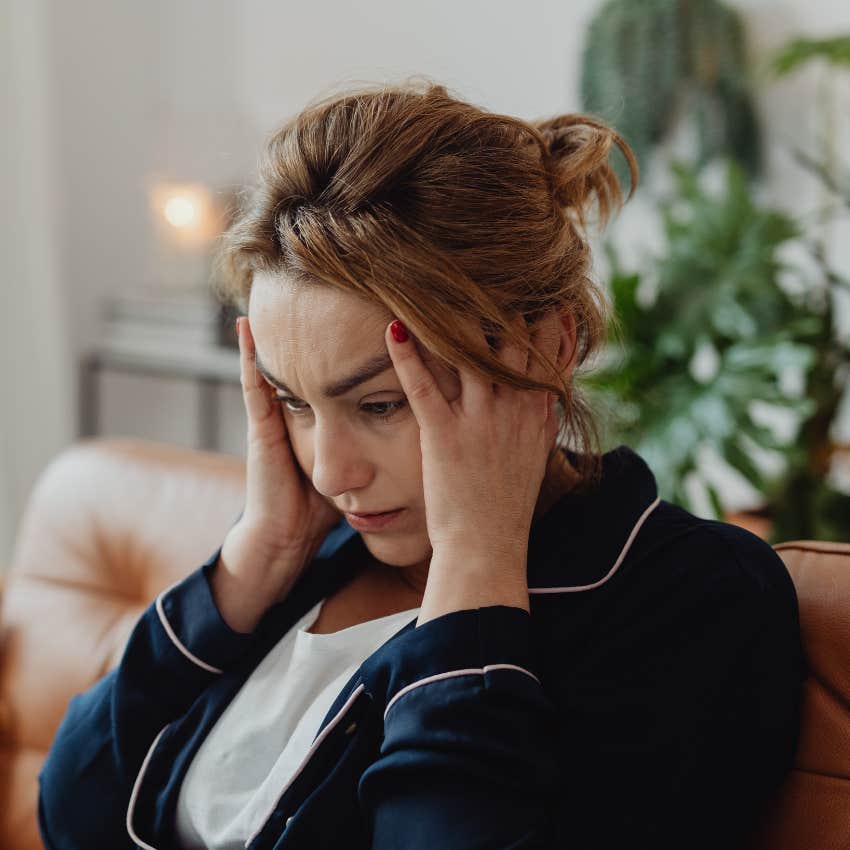 Woman holding her head while experiencing brain fog. 