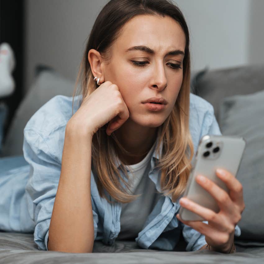 Depop seller looking confused staring at her phone. 