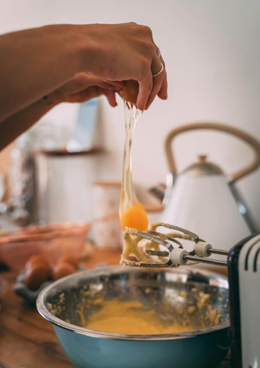 woman cracking an egg over a bowl