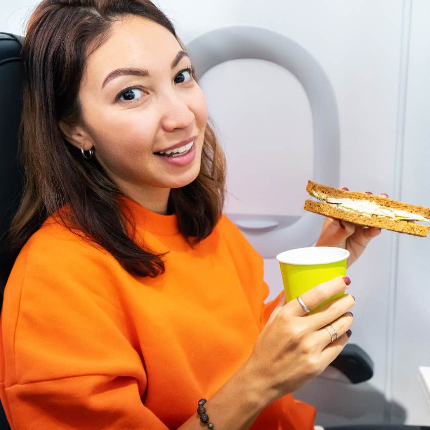 Woman eating a sandwich on an airplane