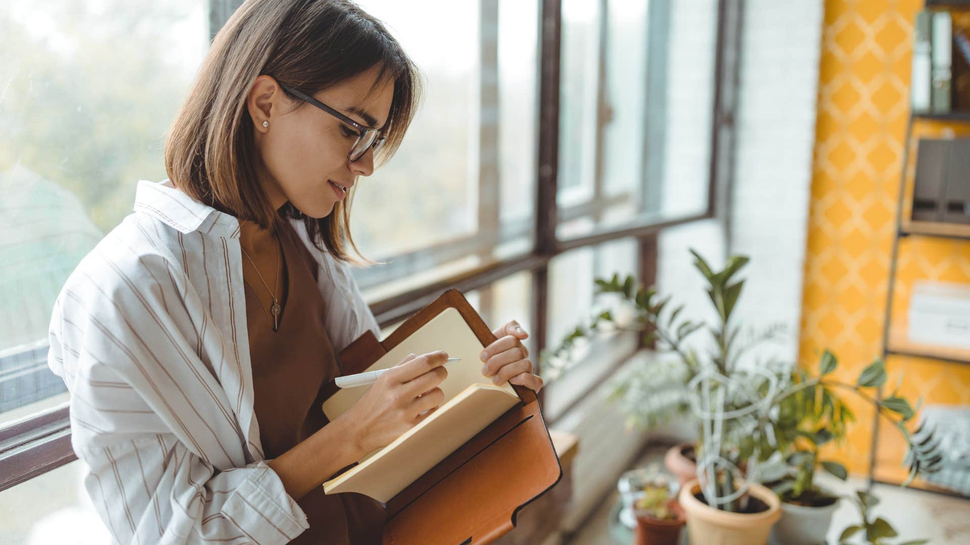 Woman looking focused while writing. 