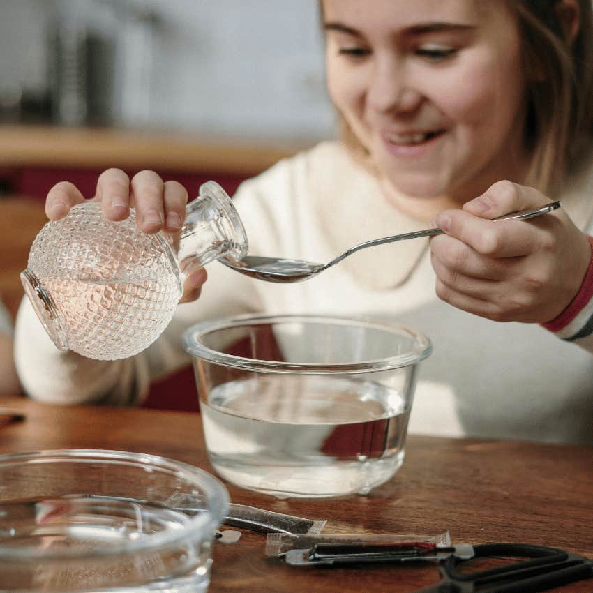 woman holding a glass container over a glass bowl