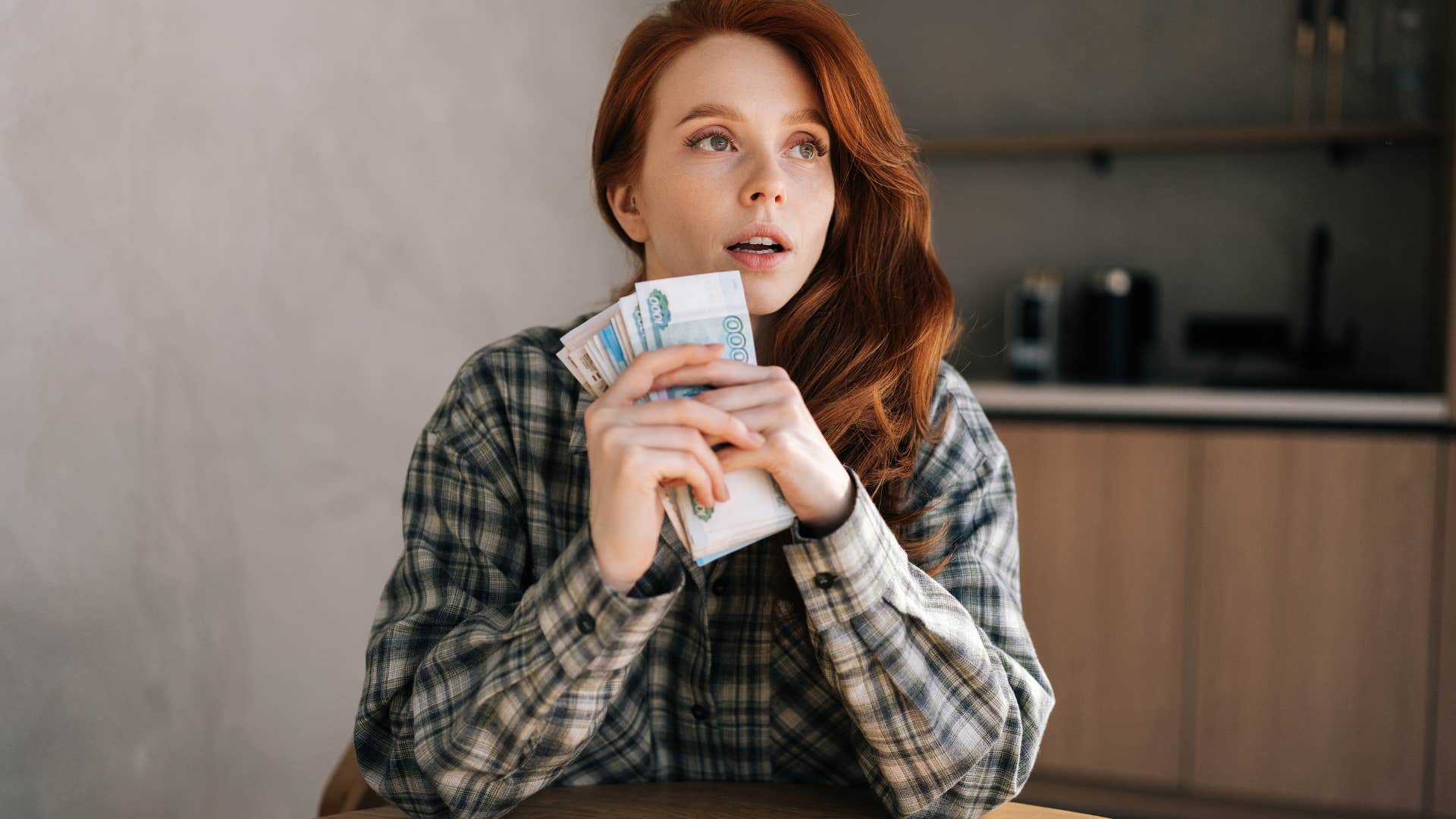 Woman looking surprised while holding cash