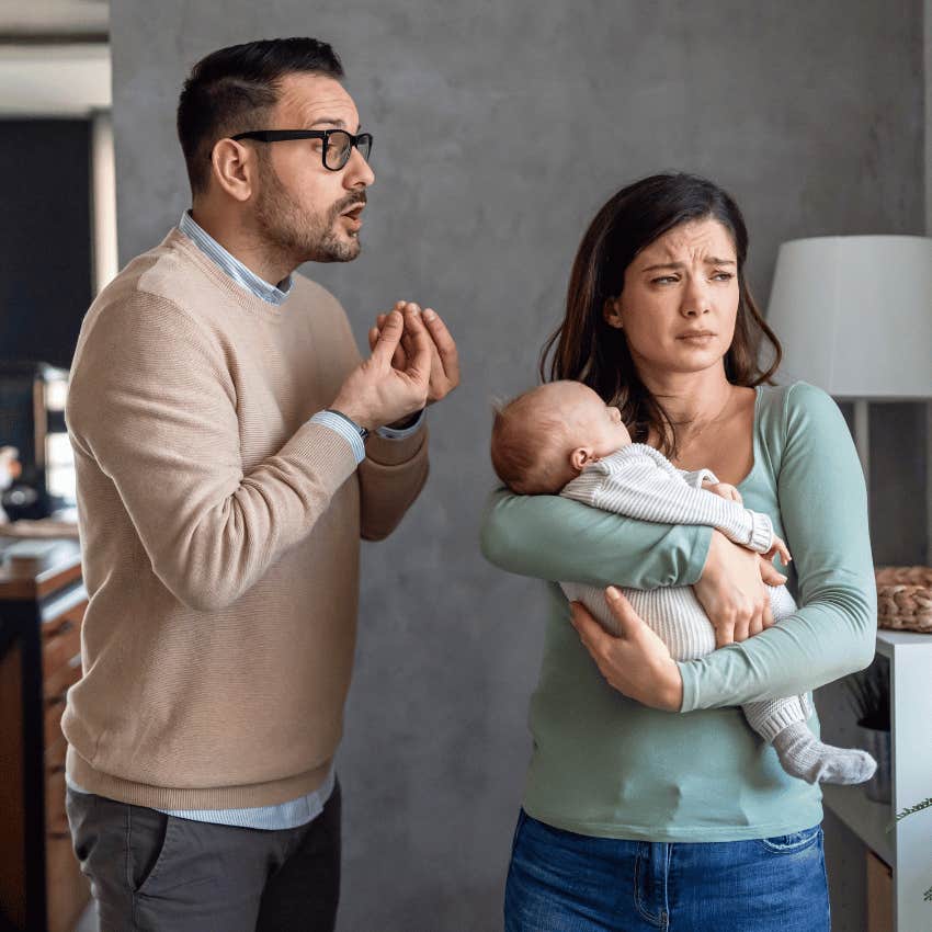 woman holding newborn while man is complaining