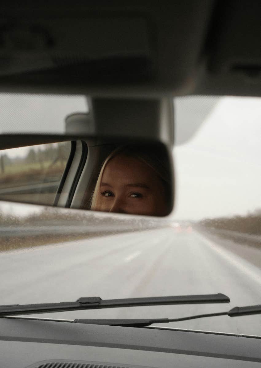 woman looking at rearview mirror