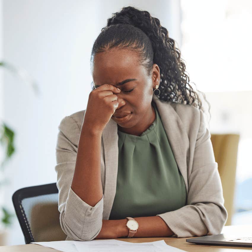 woman in office pinching the bridge of her nose