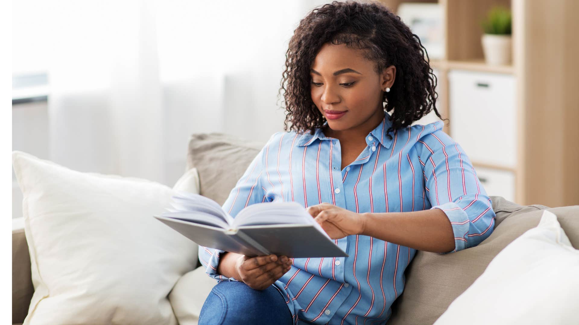 Woman reading peacefully on her couch.