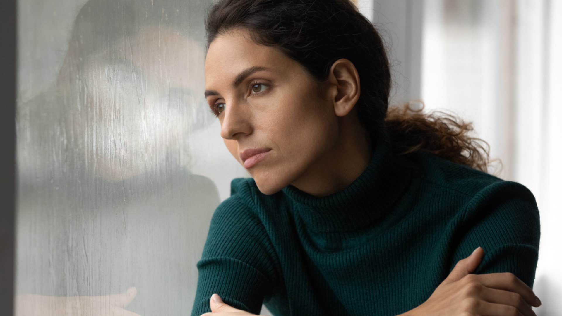 Woman reflecting looking out of a window. 