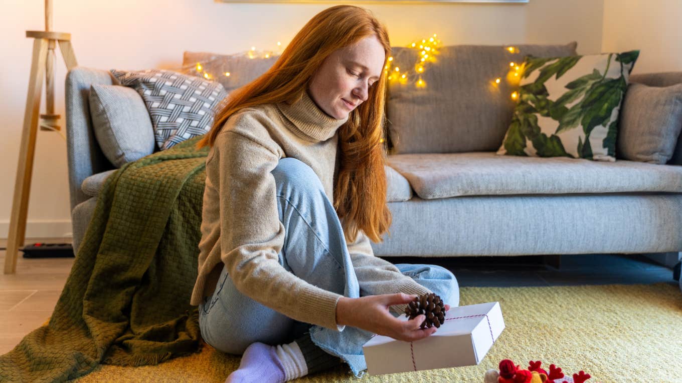 woman sitting on ground wrapping gift