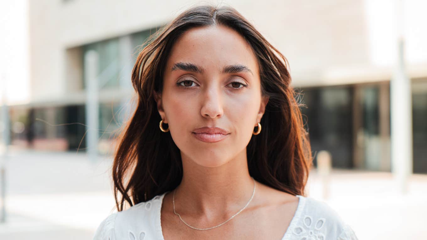 portrait of a Hispanic girl with a serious expression looking at camera