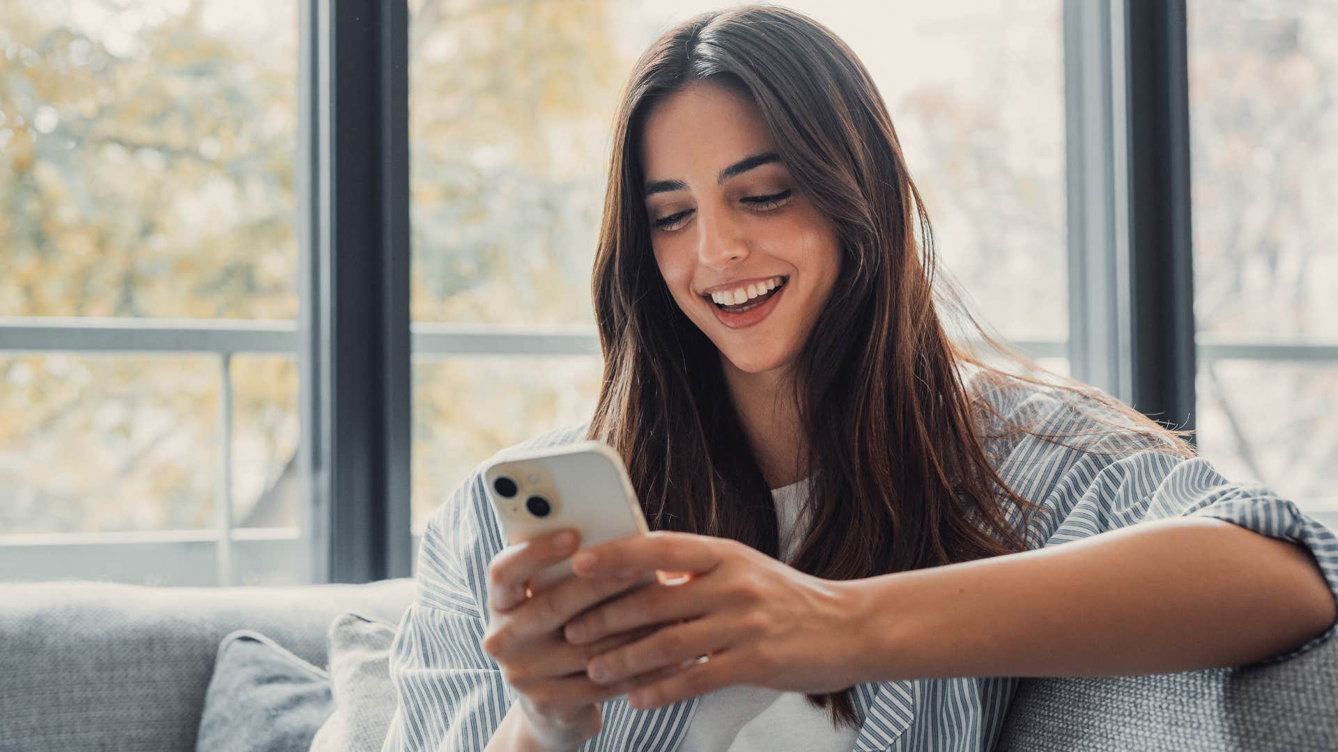 Woman looking happy and scrolling on her phone