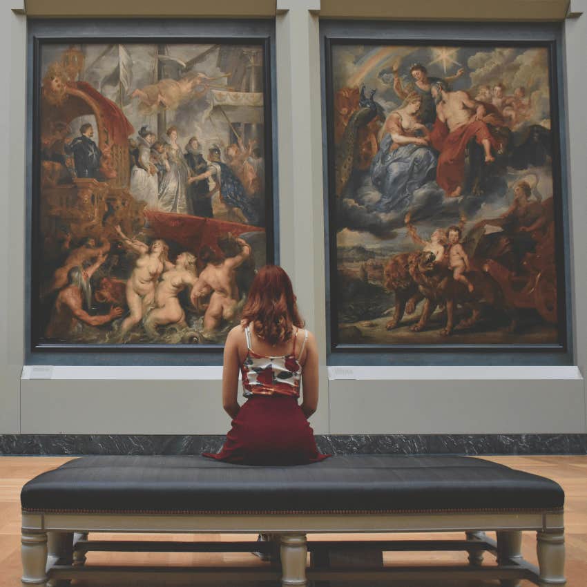 woman sitting in front of paintings